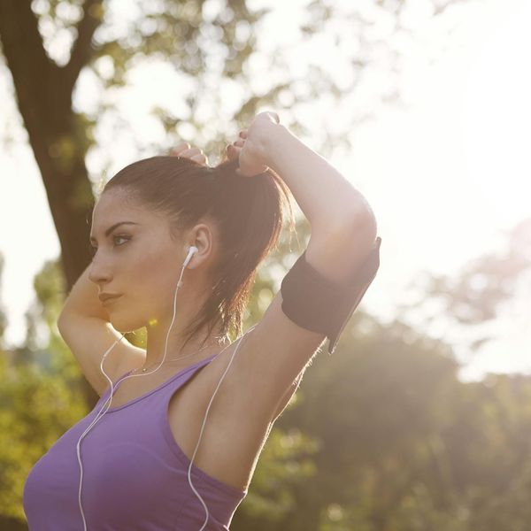 Woman feeling energized and stretching outdoors in the morning light.